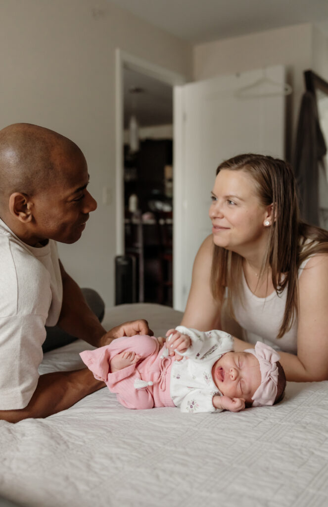 Immediate family snuggling on the couch with their newborn during a newborn photoshoot.