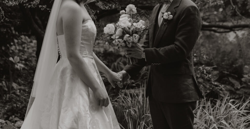 Groom giving the bride her bouquet during the first look photos during Micro wedding in Vermont.