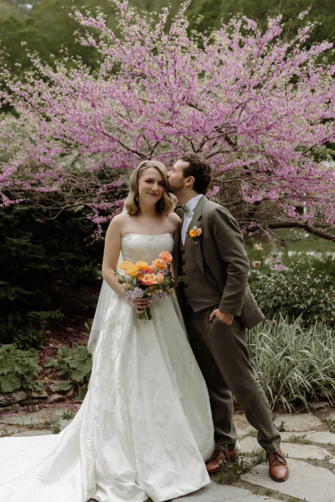 groom kissing the bride on the head pose, during portraits during Micro wedding in Vermont.