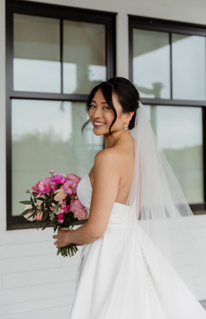 Bride smiling at the camera after bridal hair and makeup are completed, wearing her wedding dress and veil at Vermont wedding venue Essex Resort and Spa.
Beautiful Rainy Wedding Day in Vermont.