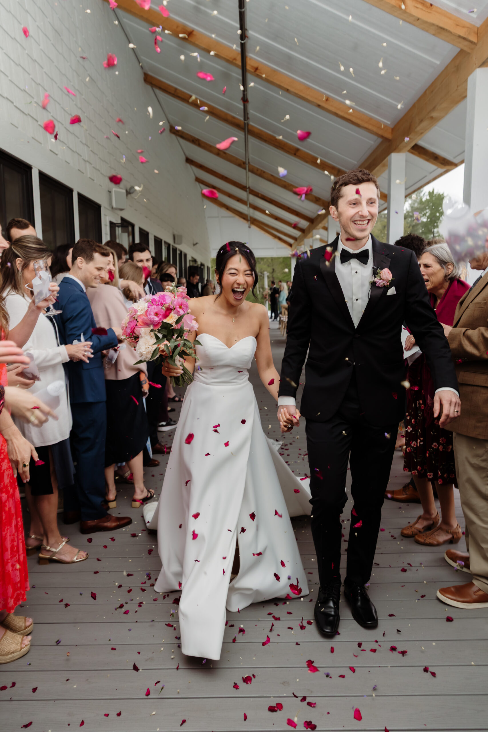 Bride and groom walking down the aisle after their ceremony on a rainy day at the Essex Resort and Spa, Vermont wedding venue.