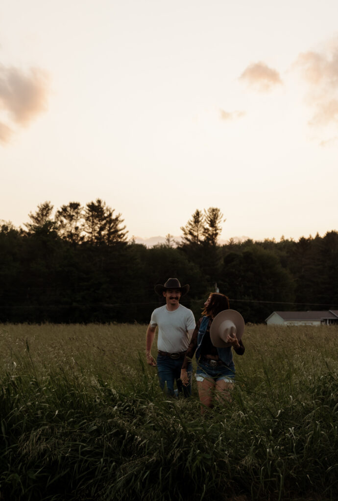 Get inspired with Vermont Engagement Photo Outfit Ideas from this Rustic Vermont engagement shoot with cowboy boots and running in a  field.