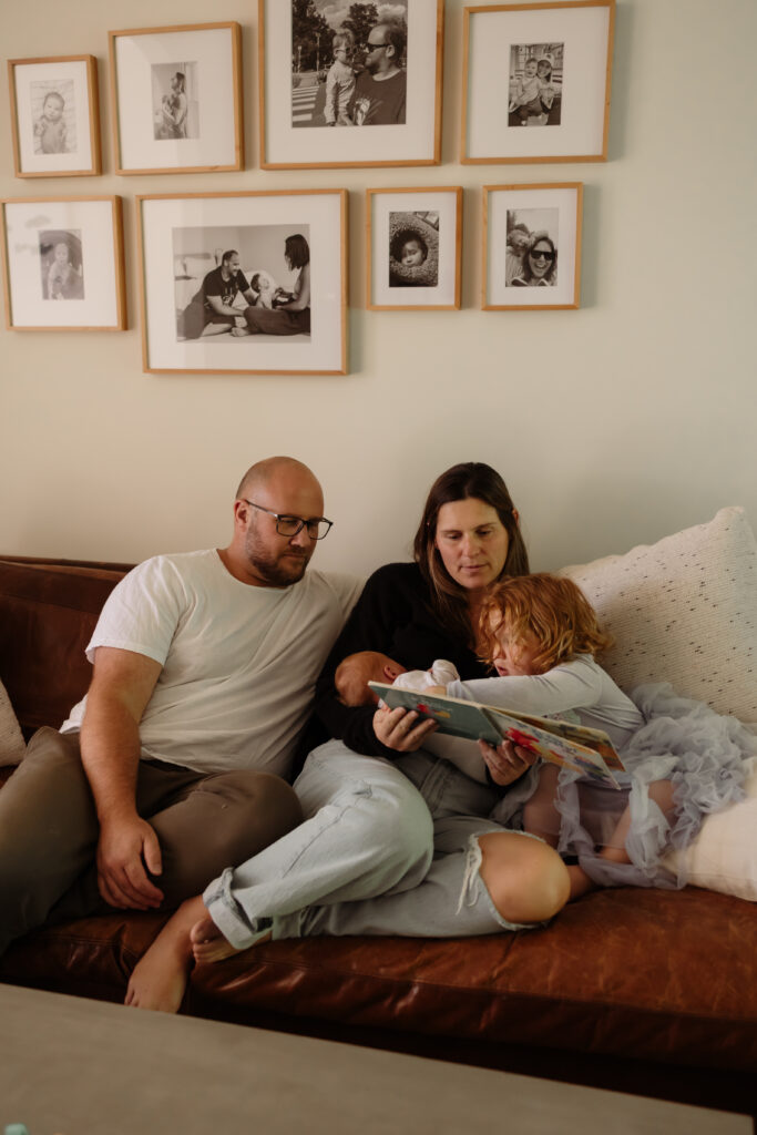 Candid family photos at home in Maine with children snuggling and reading with parents and newborn sibling.