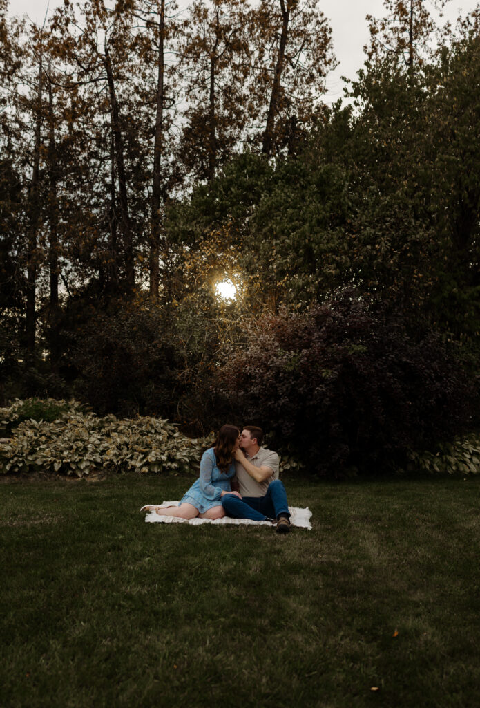 New England engagement photographer captures couple in the grass at sunset in Maine