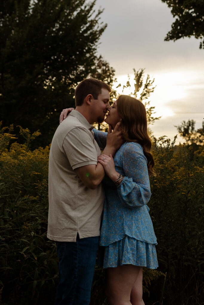 Couple kissing in warm golden light, natural South Burlington, Vermont field backdrop