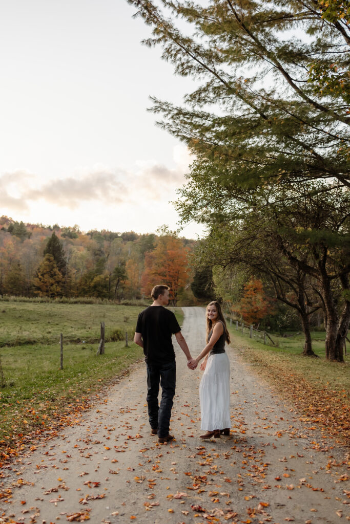 Wide-angle engagement portrait with mountains and golden leaves | Rangeley Maine photographer