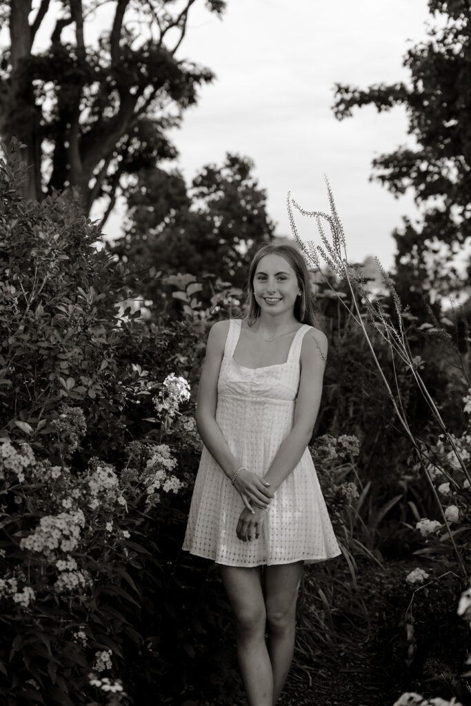 Maine coastal senior photo, girl in flowy dress laughing by the ocean during golden hour.