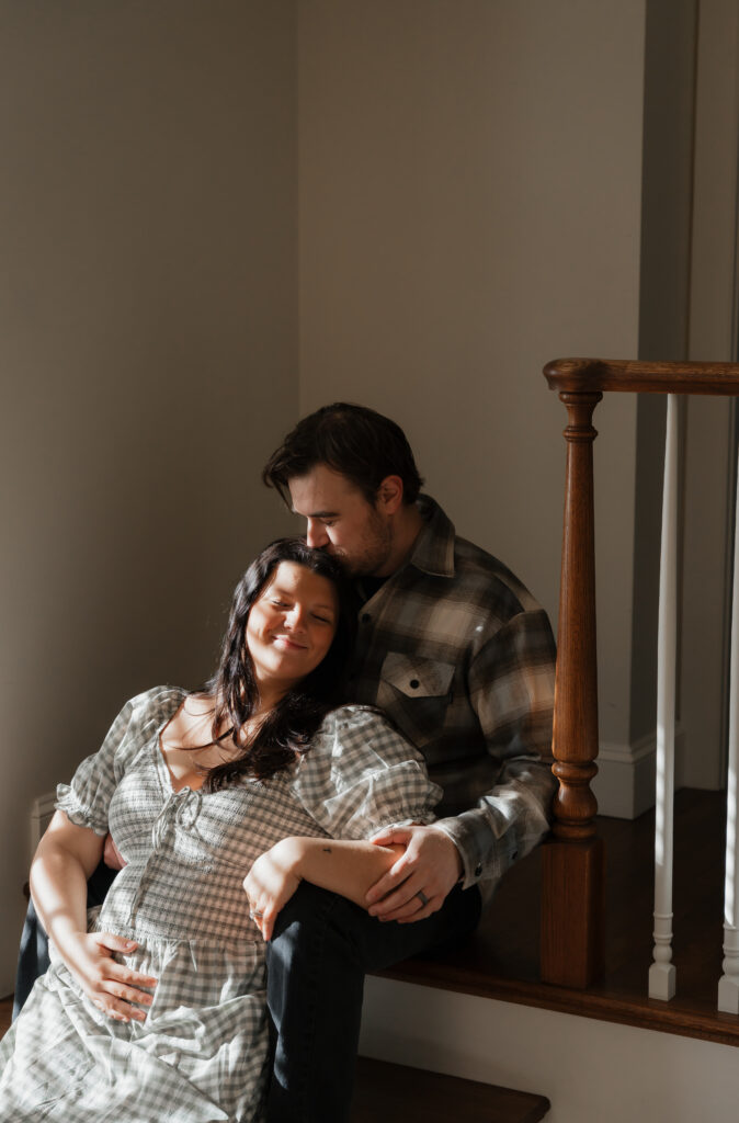 Pregnant woman in flowing dress on Maine property steps during maternity photo session